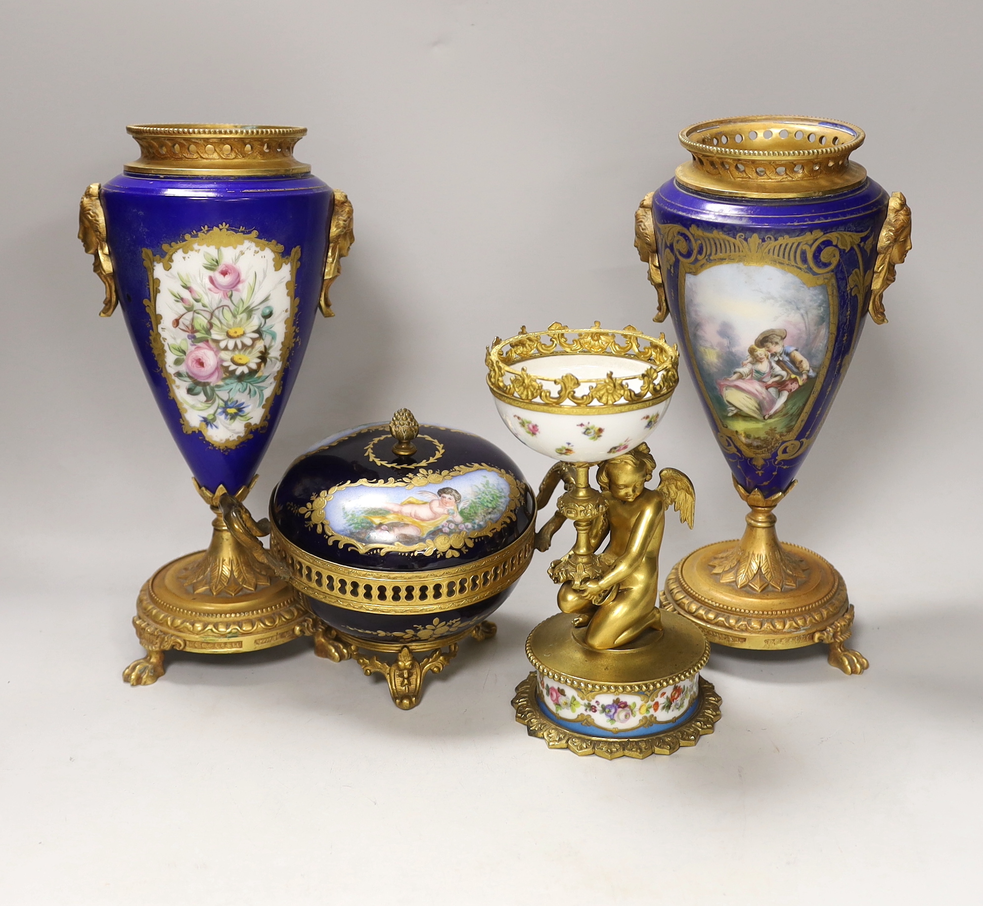 A pair of Sevres style porcelain ormolu mounted vases, a similar putti stemmed cup and a bowl and cover, tallest 27cm